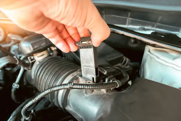 Dirty Mass Air Flow (MAF) sensor being inspected during check engine light diagnosis to restore proper airflow measurement.