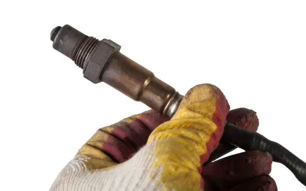 Mechanic replacing a faulty oxygen sensor to diagnose a check engine light and improve engine performance.