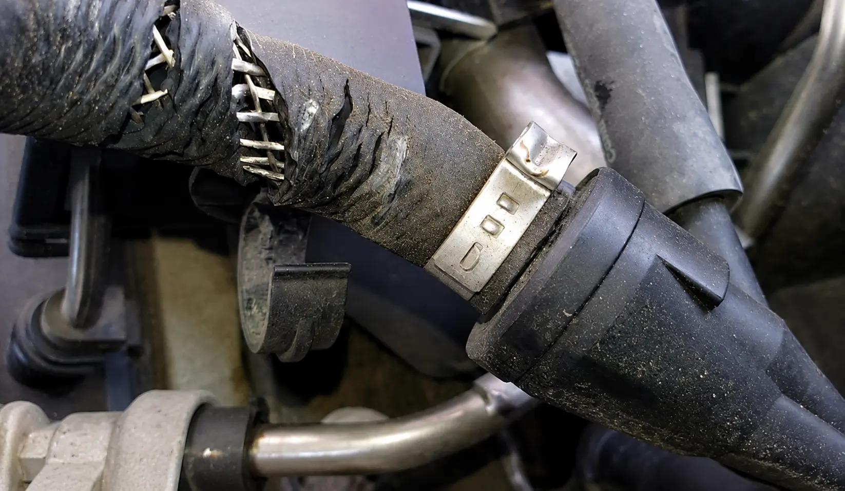 Cracked vacuum hose causing a vacuum leak that triggers the check engine light and affects engine performance.