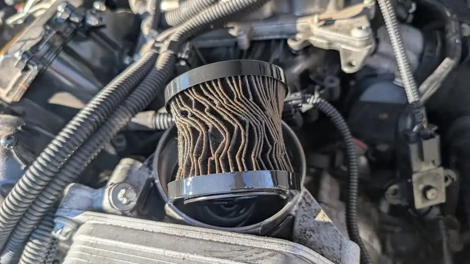 Damaged engine oil filter showing a restricted filter element that can reduce oil flow and engine lubrication.